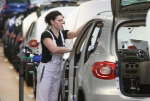 A female worker assembles parts at the Volkswagen car factory 