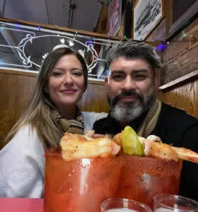 husband and wife posing with two bloody mary's