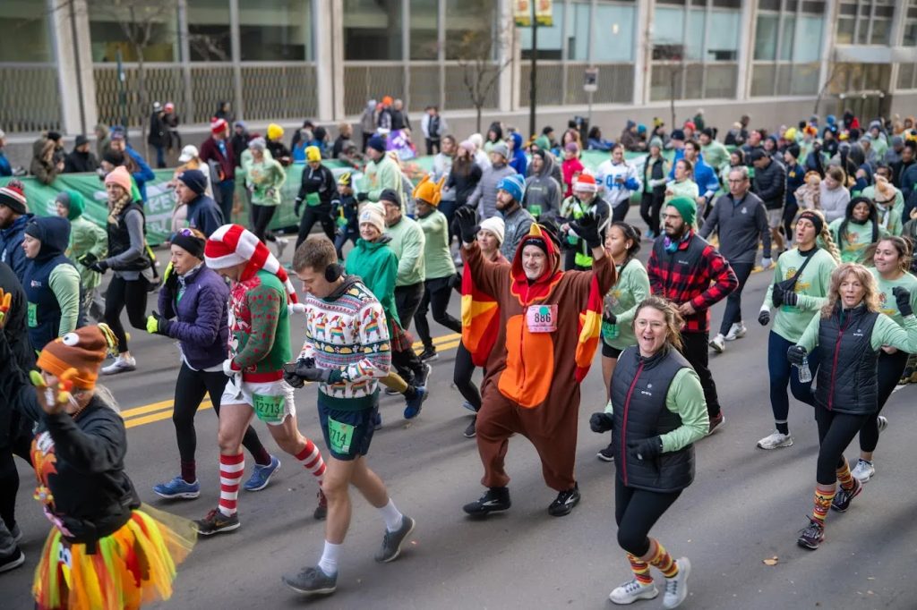 people walking and run on the streets of Detroit for the Turkey Trot. Use in an article about the Detroit Thanksgiving Parade